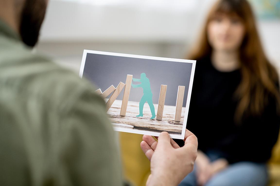 Therapeut hat Foto in der Hand, dass eine spezielle Konstellation zeigt.