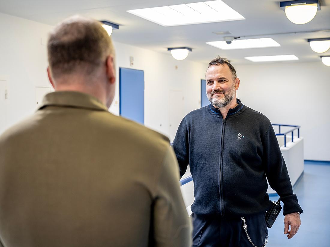 Ein Inhaftierter spricht mit einem Aufseher/Betreuer.