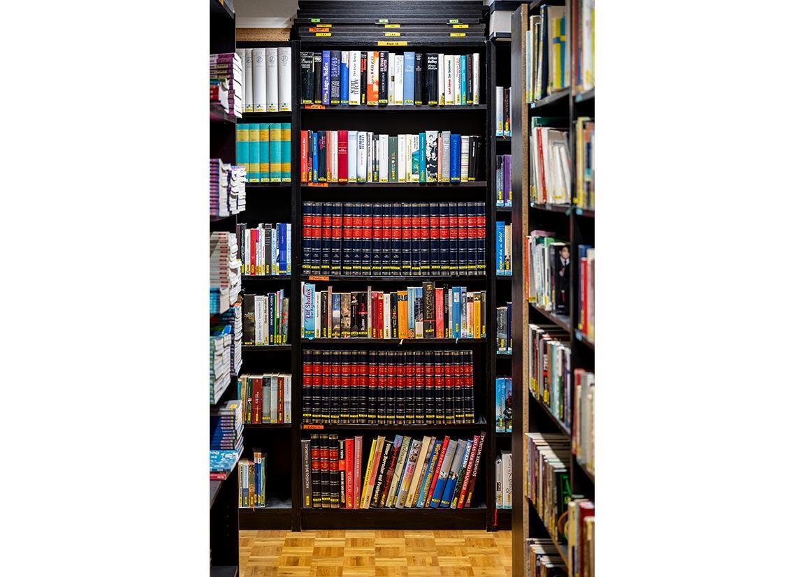 Eine Bibliothek im Gefängnis mit vielen bunten Büchern.