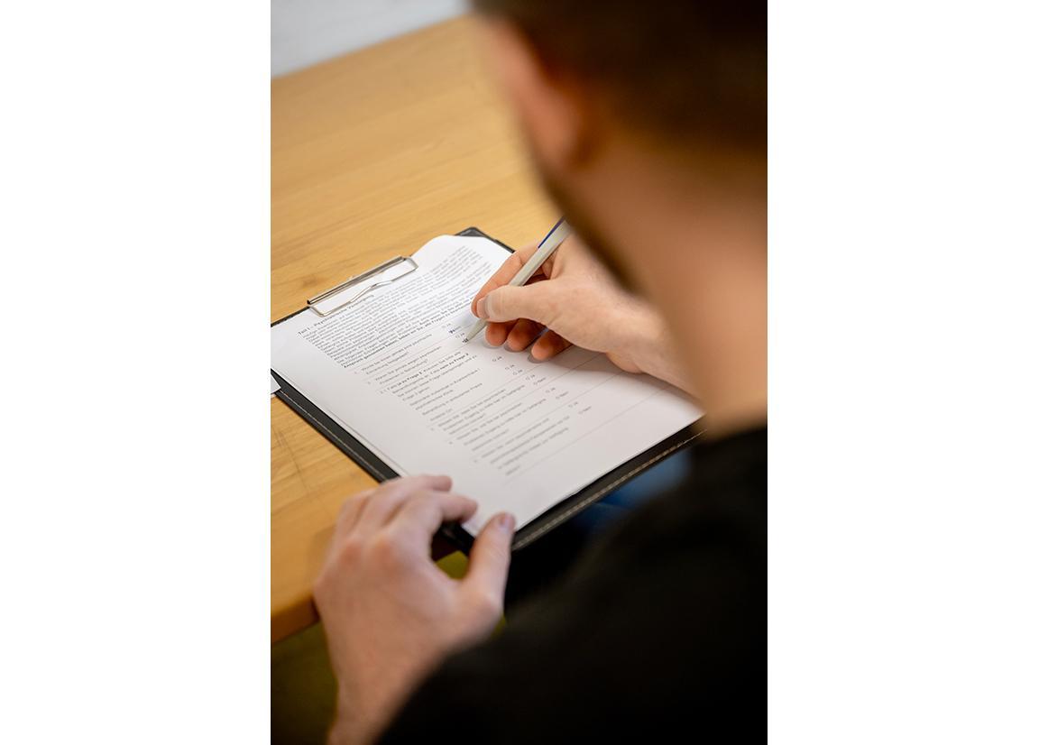 Das Bild zeigt einen Menschen, der einen Fragebogen ausfüllt.