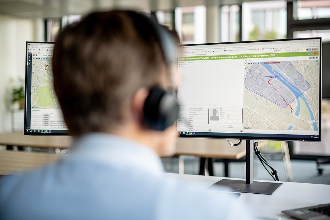 Mitarbeiter sitzt vor Computerbildschirm und sieht eine Karte, auf der das Bewegungsraster der überwachten Person eingetragen ist.