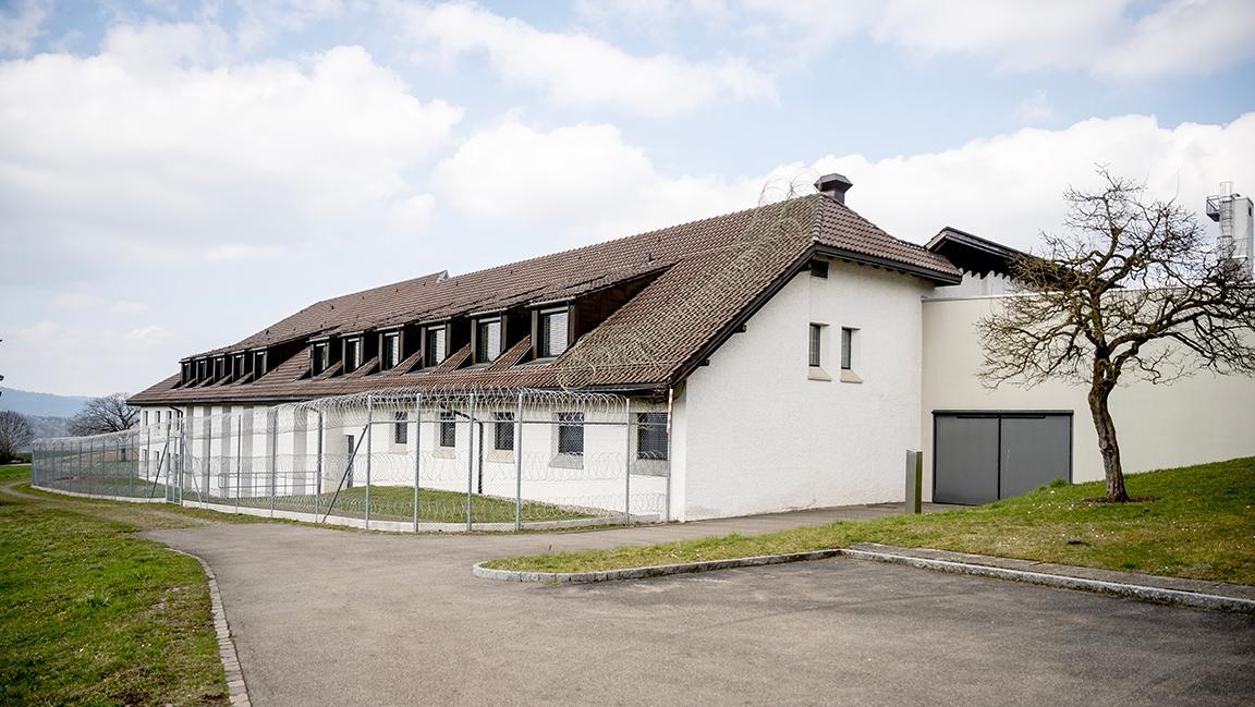 Hinterseite der geschlossenen Abteilung. Das Gebäude ist von einem Zaun mit Nato-Draht umgeben.