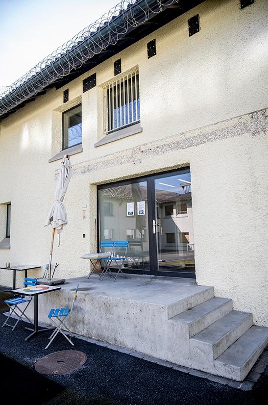 Im Innenhof der geschlossenen Abteilung wurde das Vordach entfernt. Man sieht eine Glastür, eine Treppe und ein Tischlein mit Stühlen.