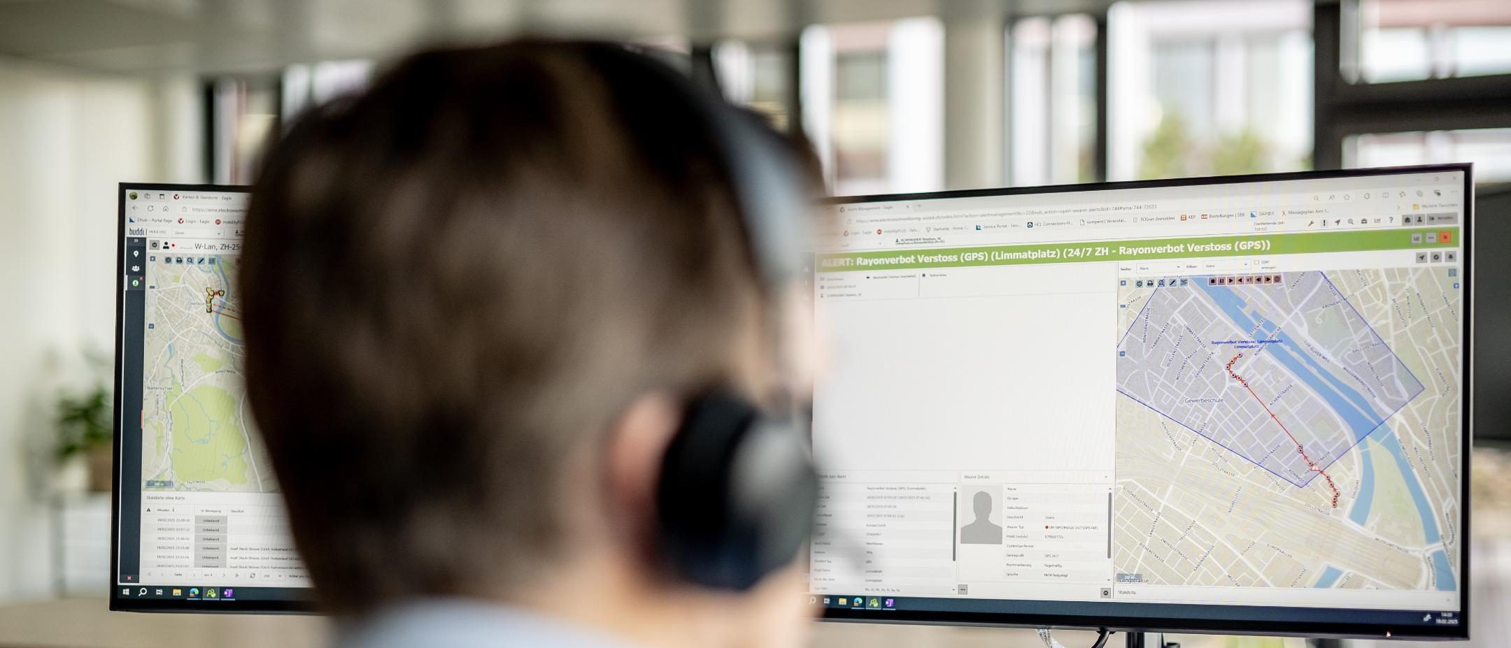 Mann schaut auf Computerbildschirm, dort sieht man eine GPS-Karte.