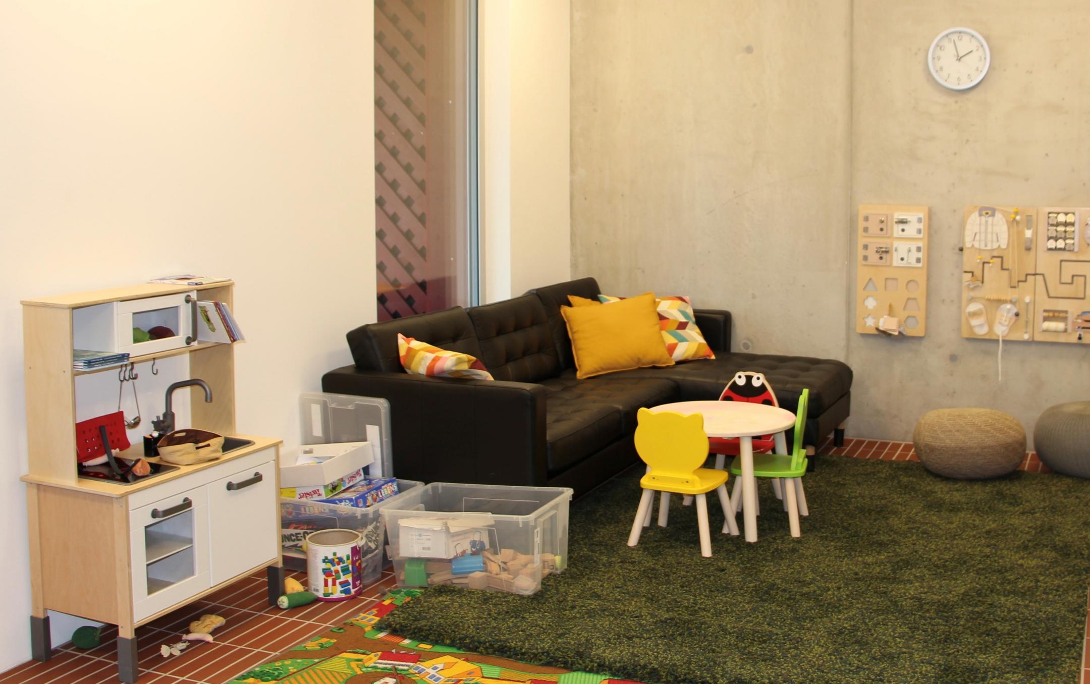 Gemütlicher Raum mit Spielzeug, Sofa und Teppich