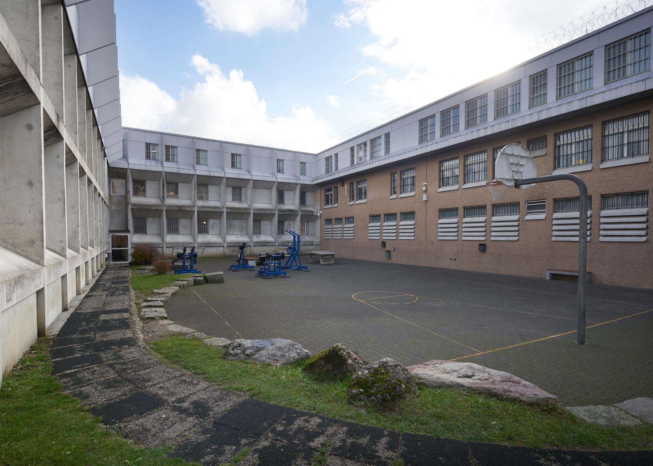 Abgebildet ist der Spazierhof des Gefängnisses Pfäffikon. Auf dem Bild zu sehen sind ein Basketballkorb, Kraftgeräte und ein Tischtennistisch.