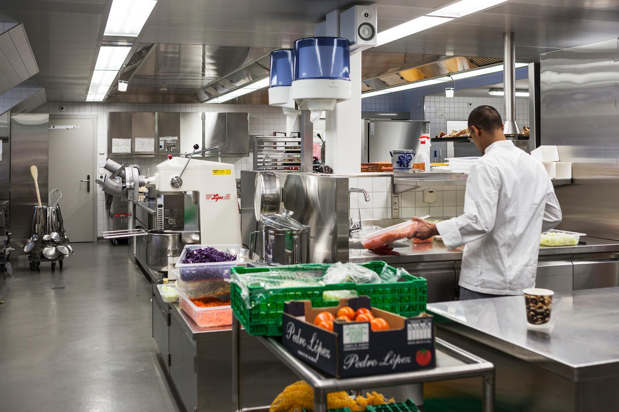 Küche mit Koch und Lebensmitteln.