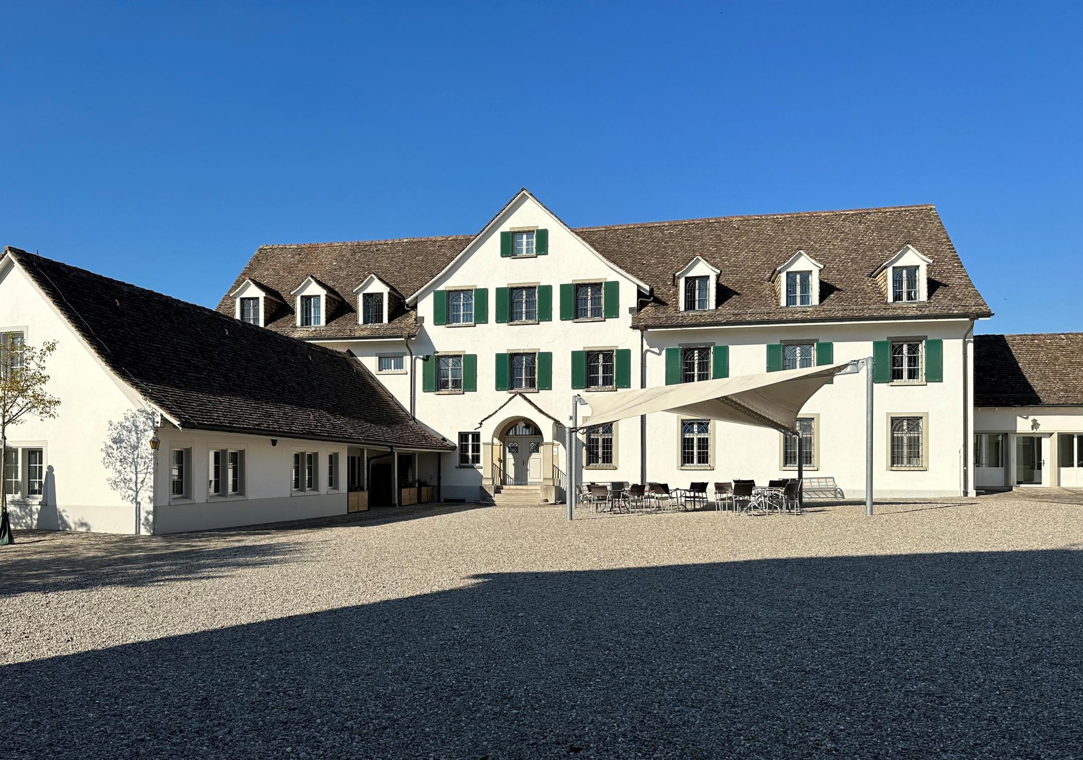 Altes Gebäude mit Kiesplatz und Sitzbereich