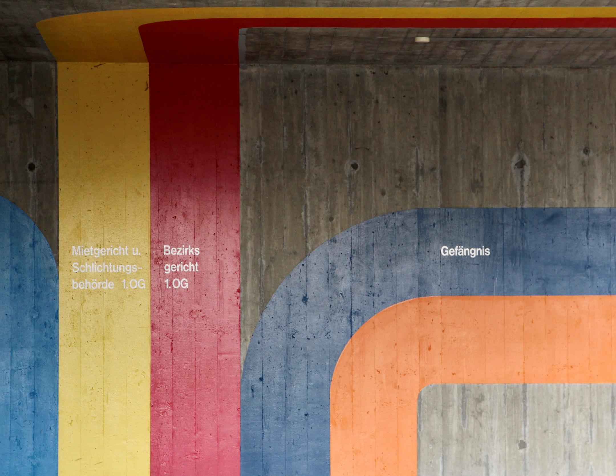 Betonwand mit bunten Wegweisern