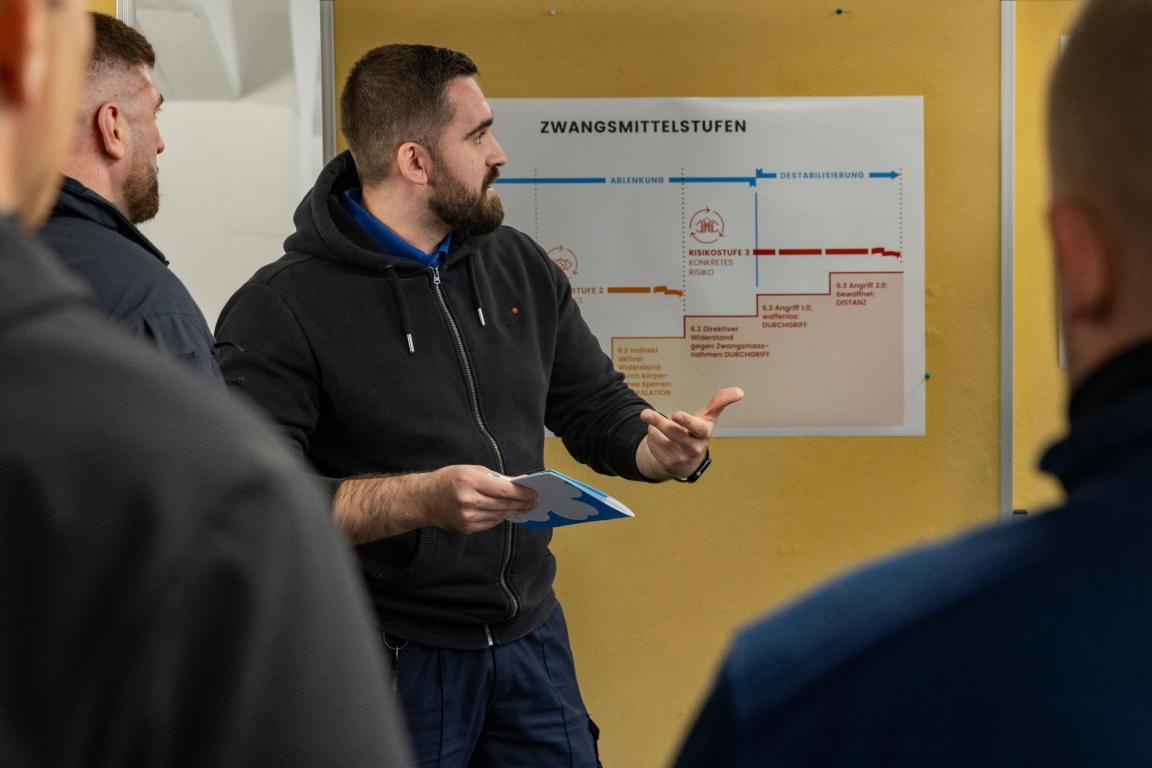 Personen diskutieren vor einem Plakat.