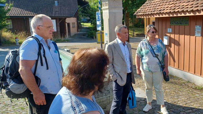 Regierungspräsident Ernst Stocker und Medienschaffende hören auf dem Rundgang dem Opfiker Stadtpräsidenten Roman Schmid zu.