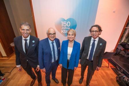 Von oben fotografiert vor einer weissen Wand mit blauem Herz und Text «150 Jahre KSW» RRnr zusammen mit CEO Guido Speck, Regierungsrat Pierre Alain Schnegg (Kt. Bern) sowie Spitalratspräsident Franz Studer.