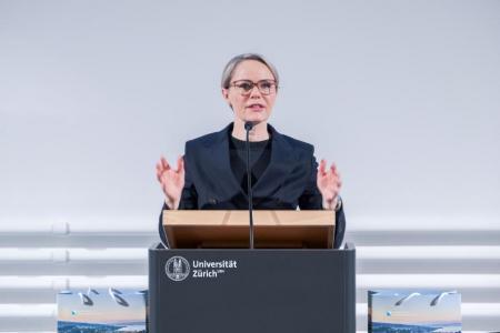 Regierungsrätin Rickli in dunkelblauem Blazer und Pullover sowie Brille tragend und mit Händen referierend am Rednerpult ins Mikrofon sprechend.