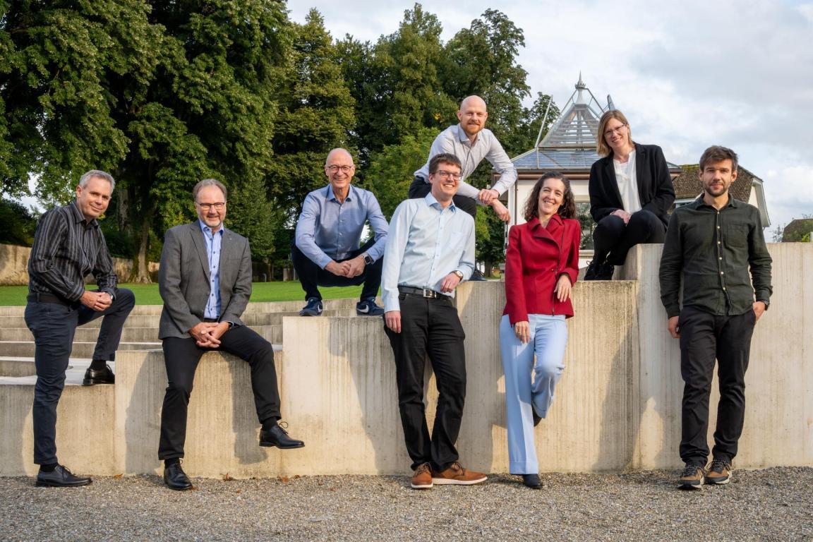 Die Labor Geschäftsleitung posiert an einer Mauer in einem Park