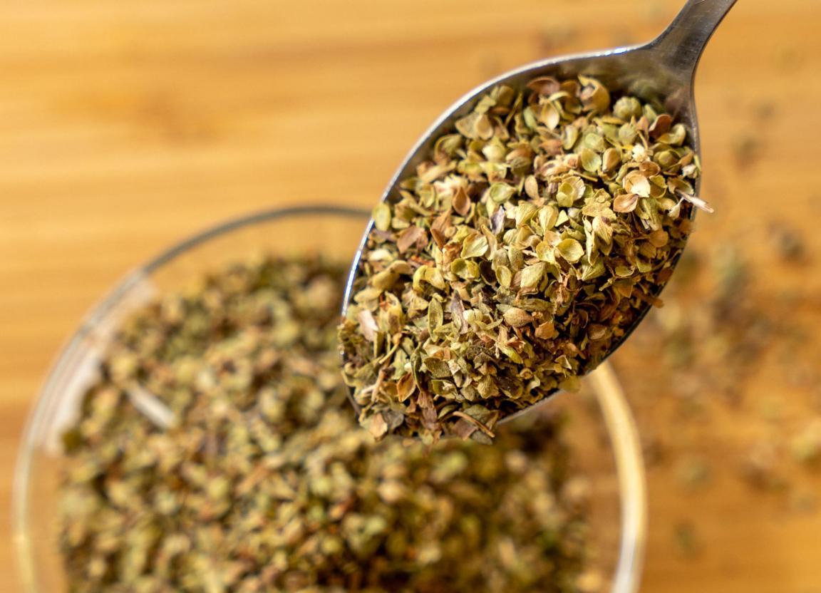 Oregano getrocknet und zerkleinert auf einem Metallloeffel