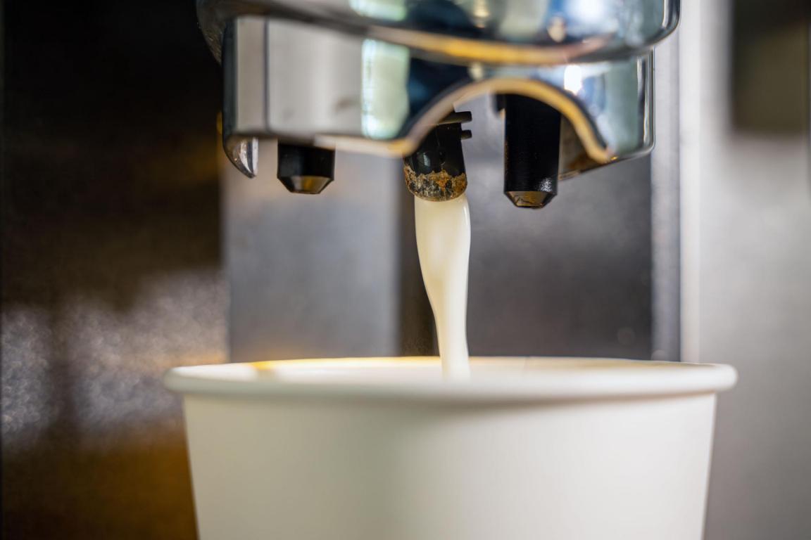 Becher unter Kaffeemaschine, wo Milch rauskommt