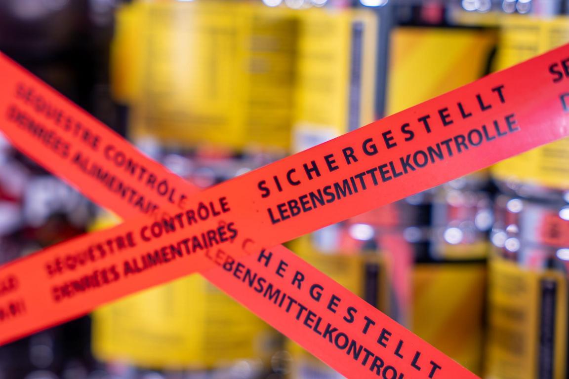 Kreuz aus orangen Absperrband vor Dosen von Sportlerlebensmitteln