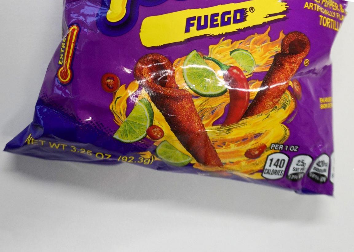 untere Hälfte einer Chipstüte mit Flammen, Chili und Limetten Aufdruck.