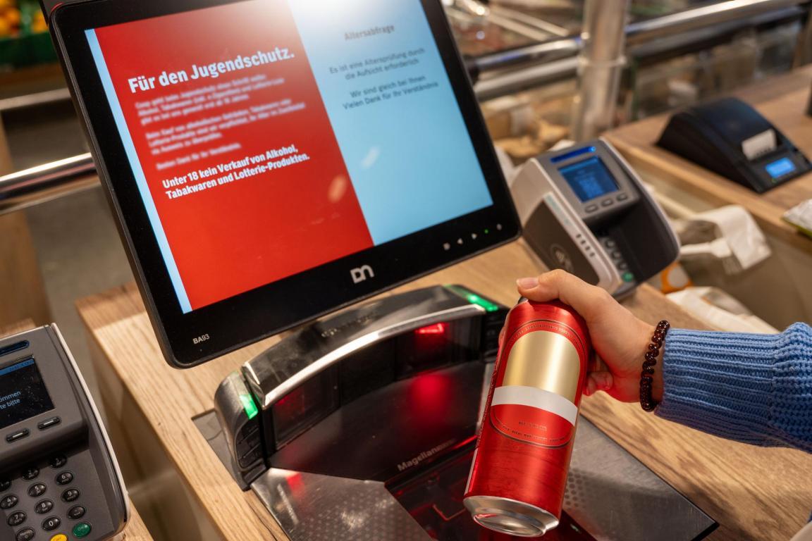Eine Bierdose wird an der Self-Checkout-Kasse gescannt. Auf dem Bildschirm erscheint die Altersabfrage.