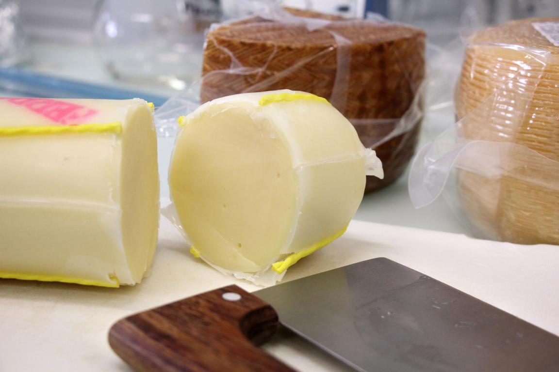 Ein Stück Käse wurde mit einem Messer in zwei Teile geschnitten.