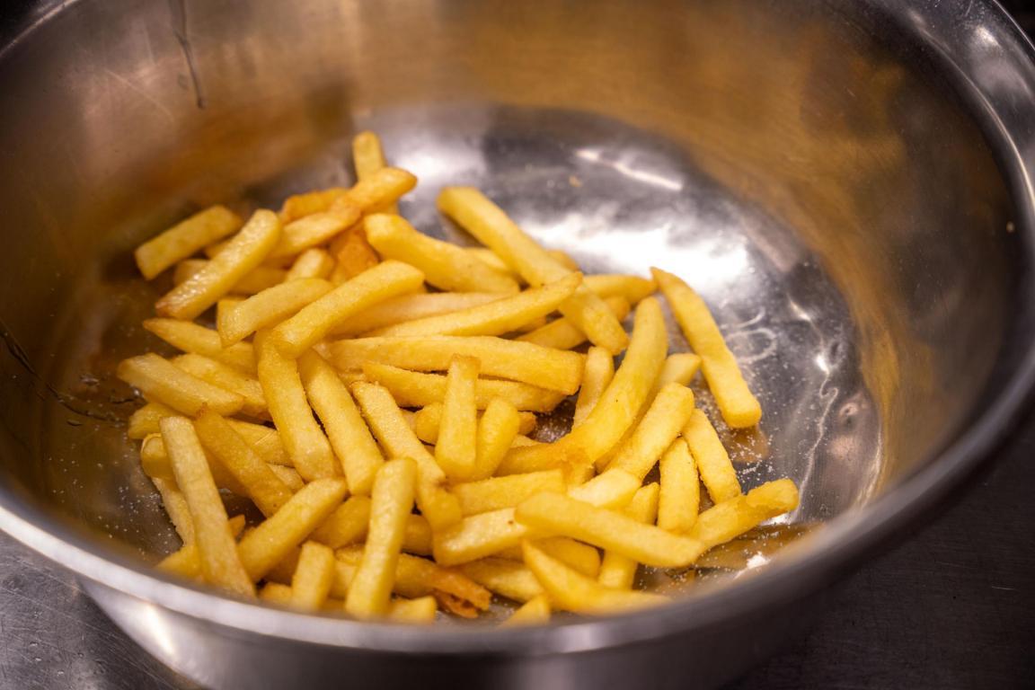 Knusprig golden frittierte und gesalzene Pommes-Frites in einer Schüssel.