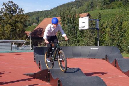 Regierungsrat Mario Fehr fährt auf dem roten Platz vom Sekundarschulhaus in Stammheim mit dem Velo eine Runde auf dem mobilen Pumptrack vom Sportamt des Kantons Zürich.