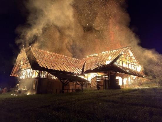 Leerstehendes Bauernhaus mit Scheune nachts im Vollbrand