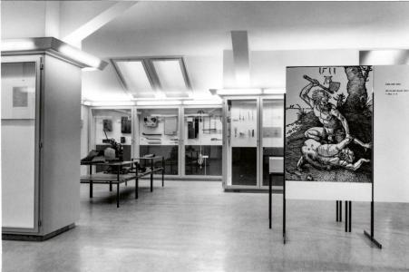 Schwarz-Weiss-Fotografie aus dem Kriminalmuseum nach dessen Öffnung für die Öffentlichkeit im Jahr 1958.. Sichtbar sind diverse Vitrinen mit Exponaten aus Kriminalfällen.