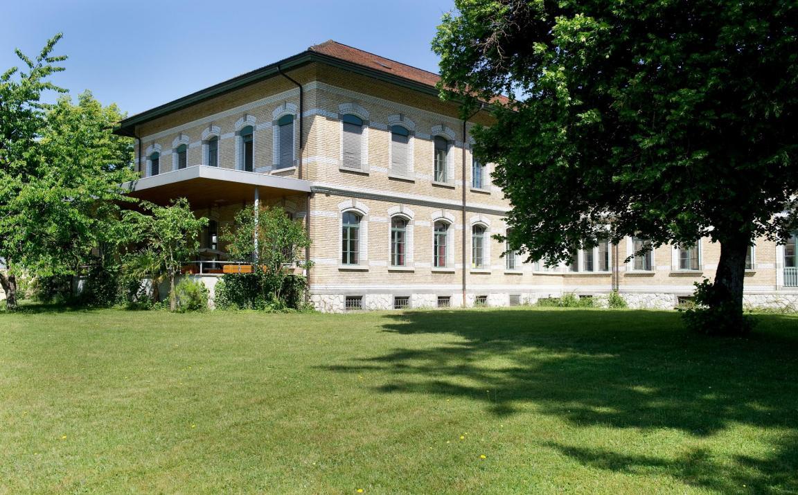 Seitenansicht der Liegenschaft der Wohngruppe. Sie ist umgeben von Bäumen. Die Wohngruppe Sonnenblume befindet sich im 1. Stock.