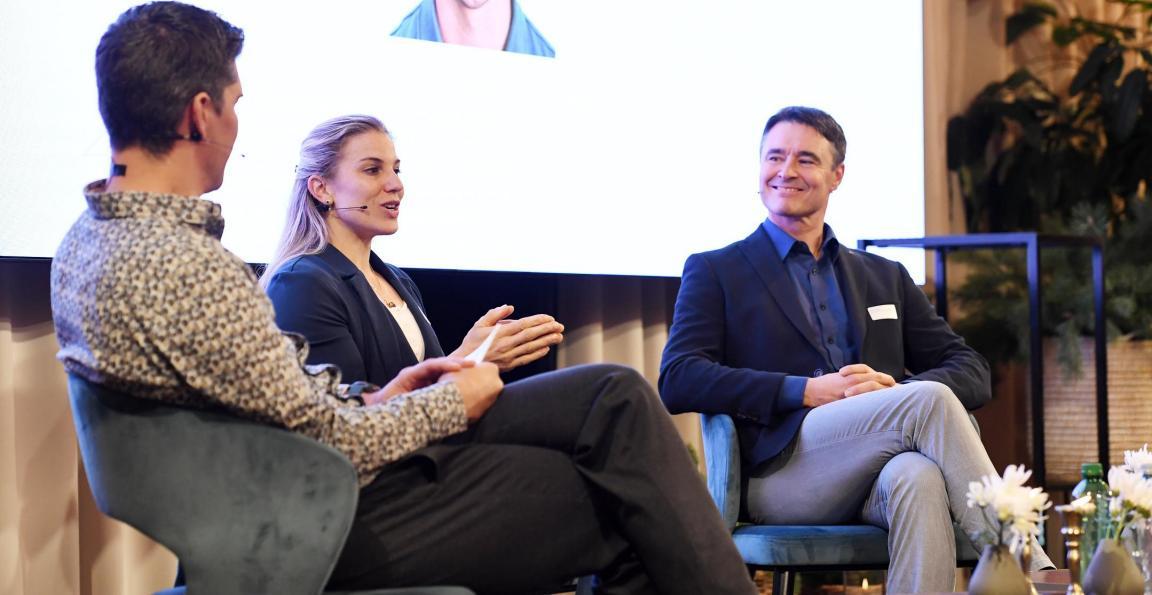Sportkletterin Petra Klingler und Mark Wolf, Leiter Trainerbildung BASPO, sitzen gemeinsam mit Moderator Franco Marvulli auf Sessel auf der Bühne beim Forum