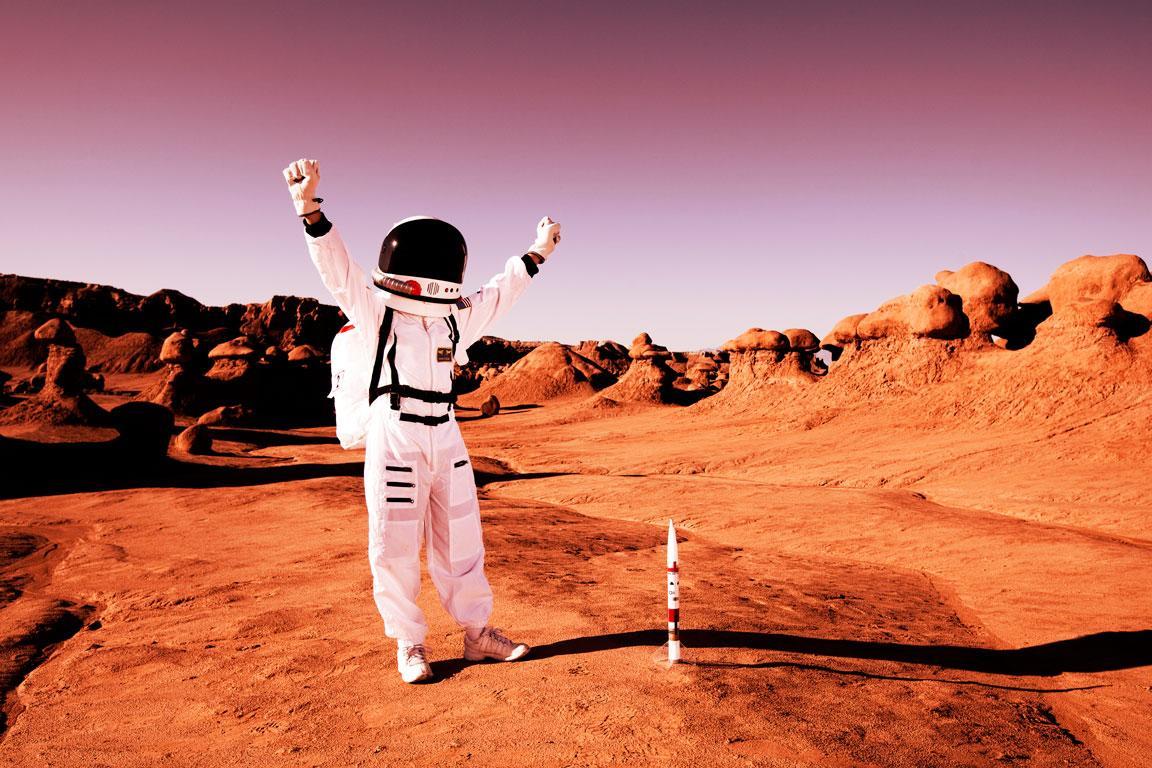 Jugendlicher Astronaut steht jubelnd auf dem Mars.