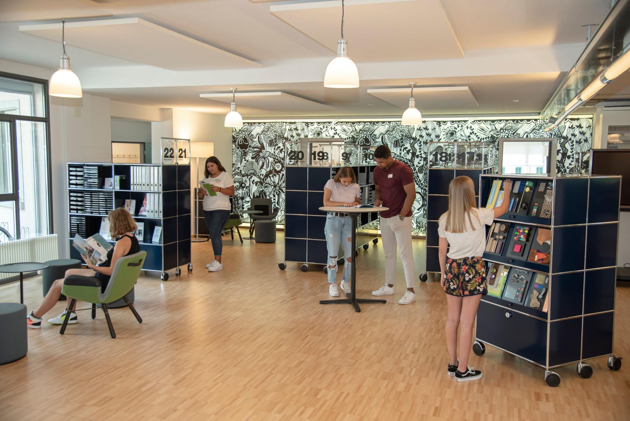 Mehrere Personen halten sich im Empfangsbereich des biz auf und studieren verschiedene Infomittel.