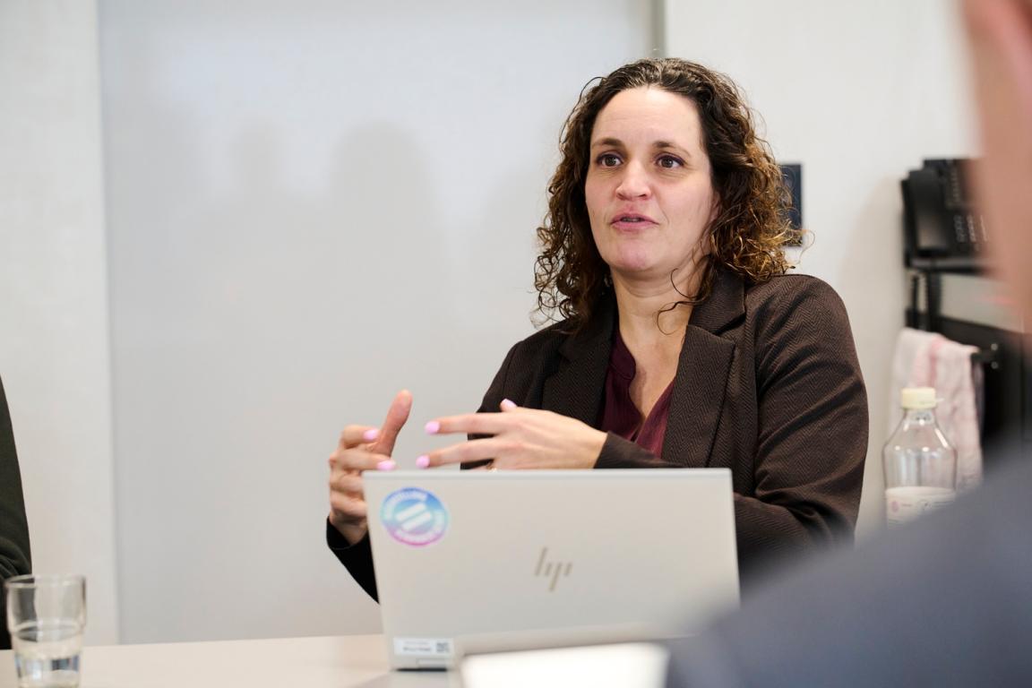 Patrizia Suplie erklärt einen Sachverhalt in einem Sitzungszimmer.