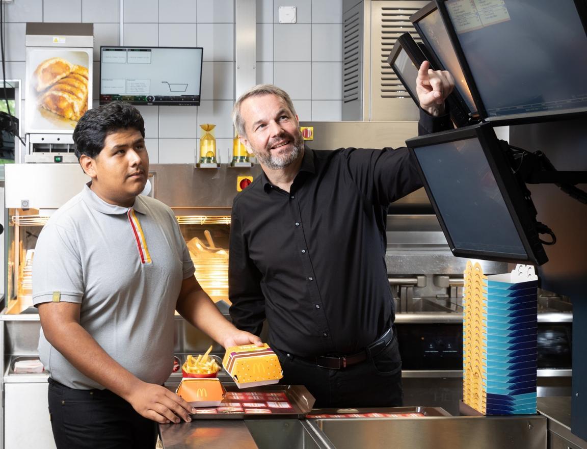 Der Lernende und sein Berufsbildner stehen in der Küche des McDonalds.