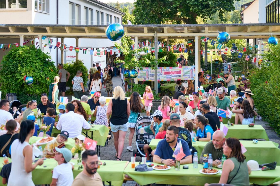 Eltern und Kinder sitzen an Festbänken.