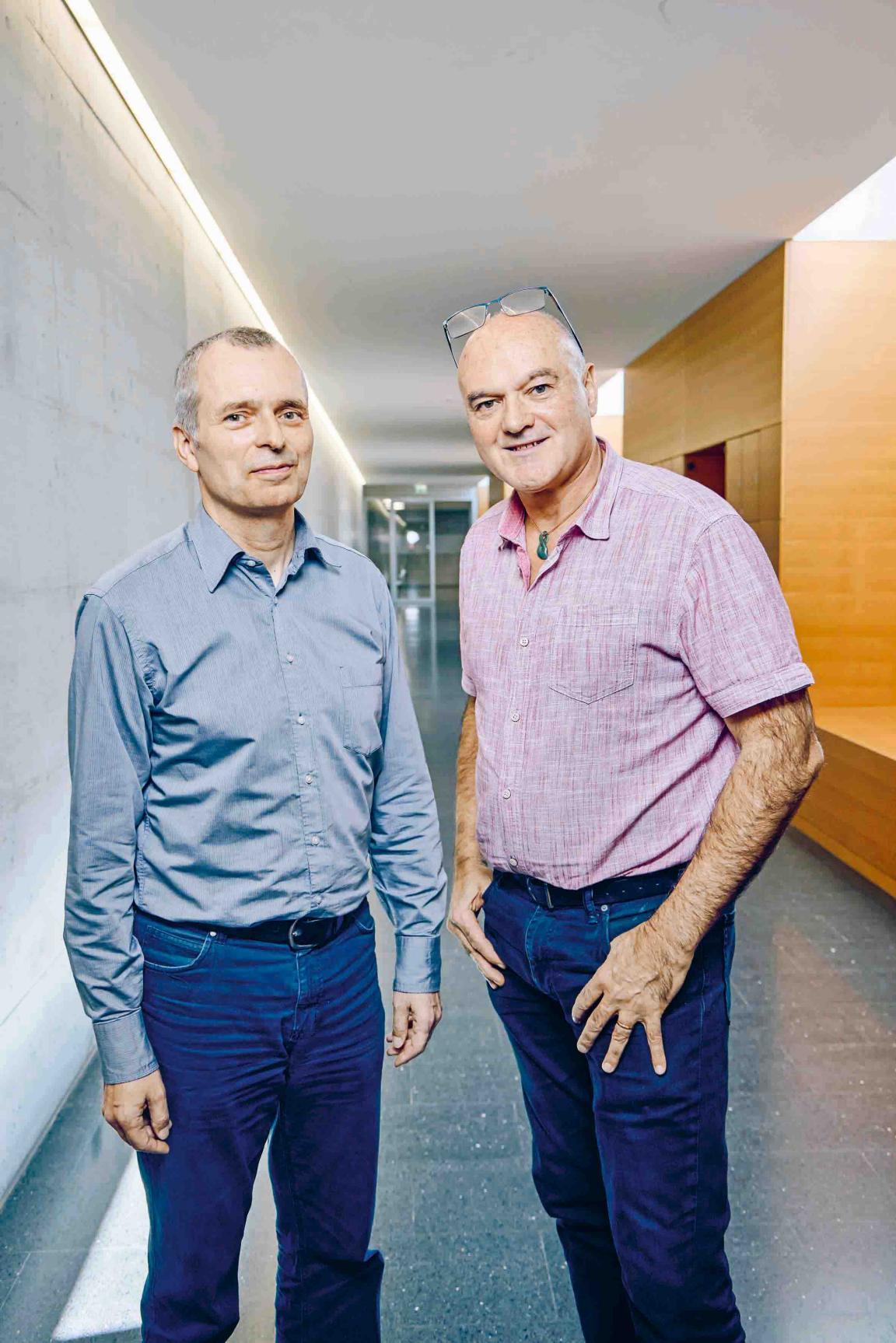 Zwei Männer im Gang eines Schulhauses.