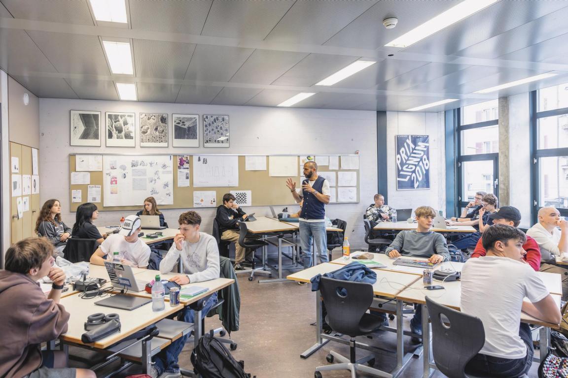 Schüler sitzen an Tischgruppen im Unterricht von Oliver Merz.