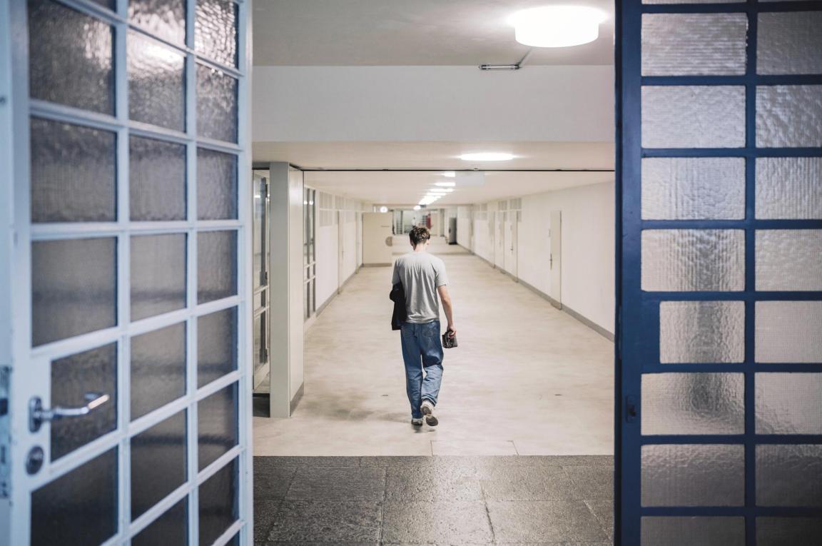 Jugendlicher läuft durch einen leeren Schulkorridor