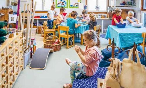 Primarschülerinnen und Primarschüler sitzen an Tischen in einem Schulzimmer