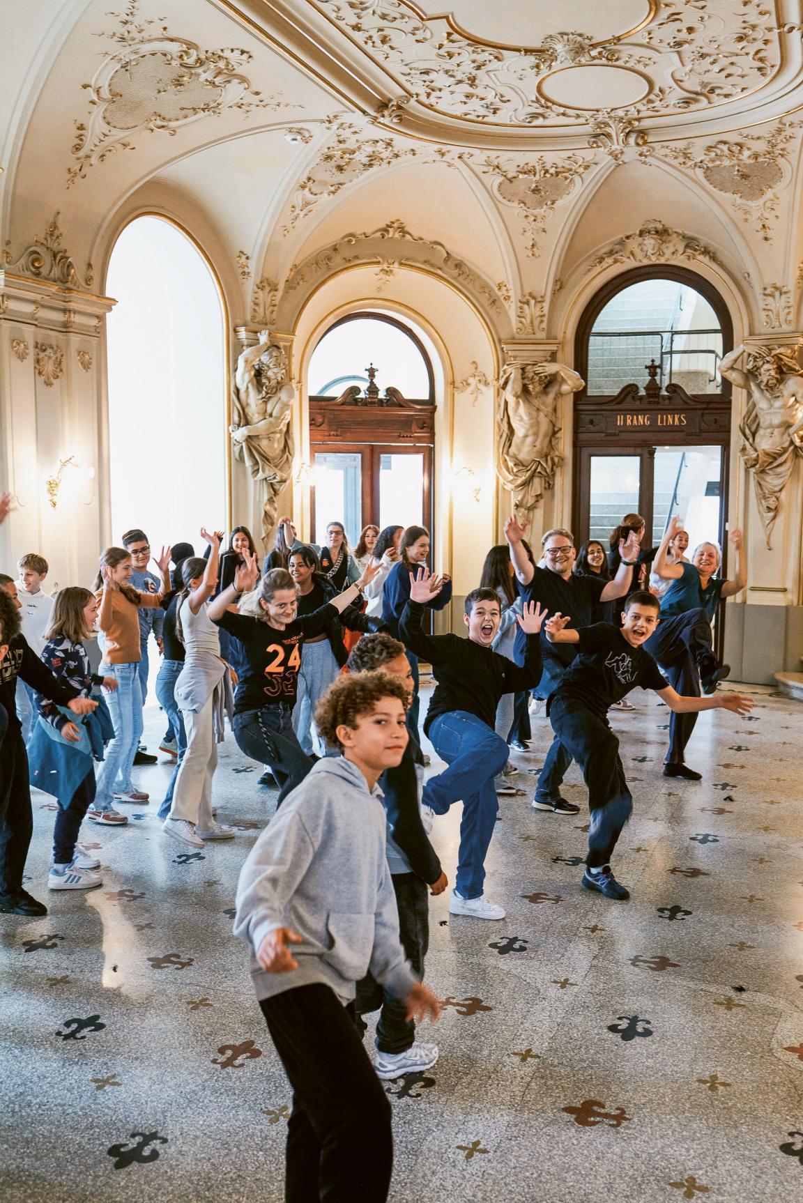 Schülerinnen und Schüler tanzen im Foyer des Opernhauses.