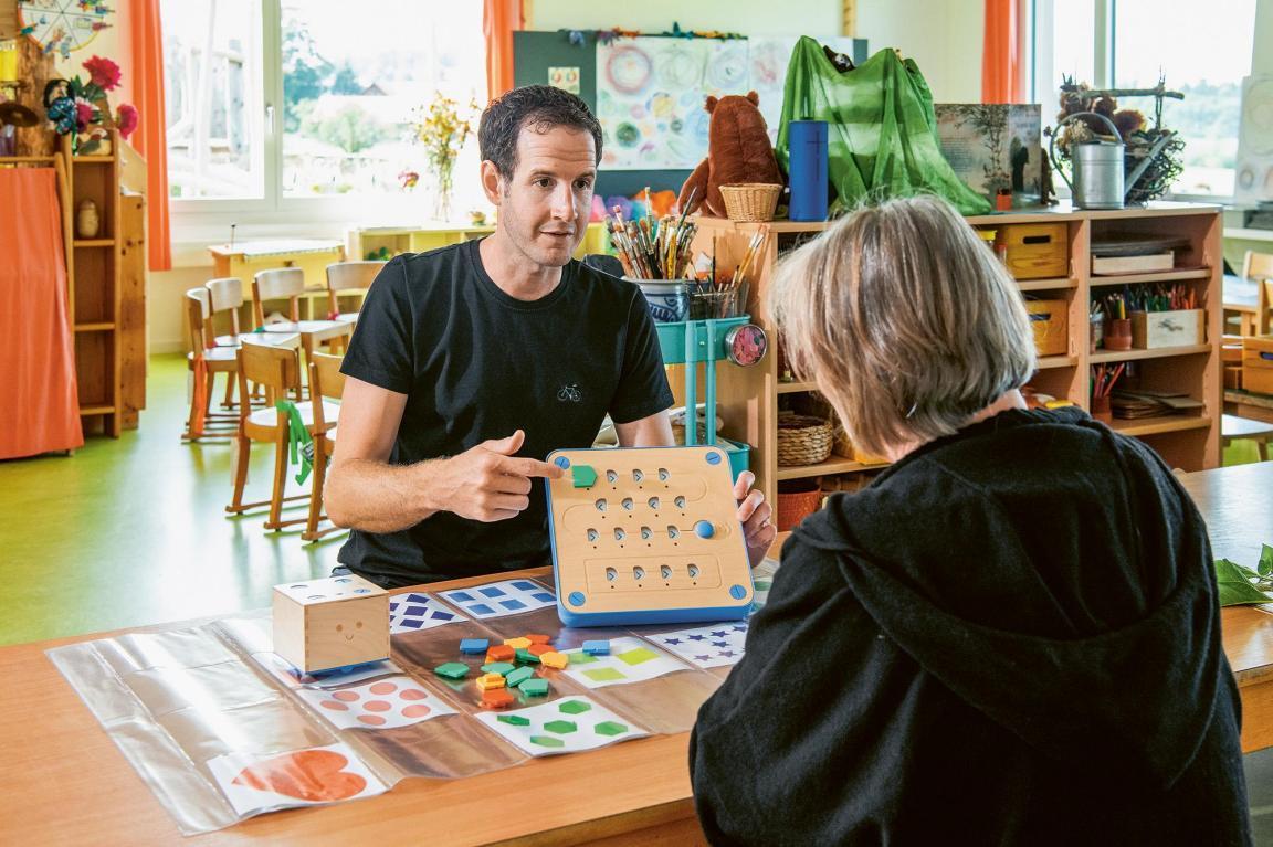 Eine Person erklärt einer aneren Person eine elektronische Schalttafel.