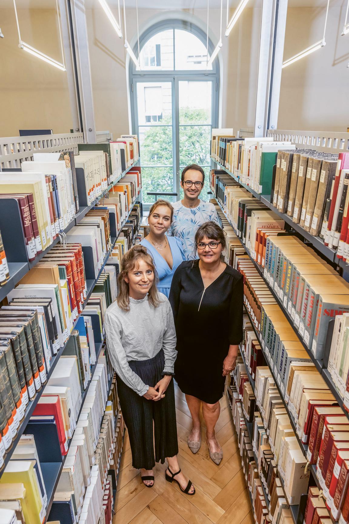 Professorin Ursula Bähler steht mit ihrem Team (Sophie Hochuli, Marigo Qoraj und Omar Itani) zwischen Bücherregalen in der Bibliothek des Romanischen Seminars.
