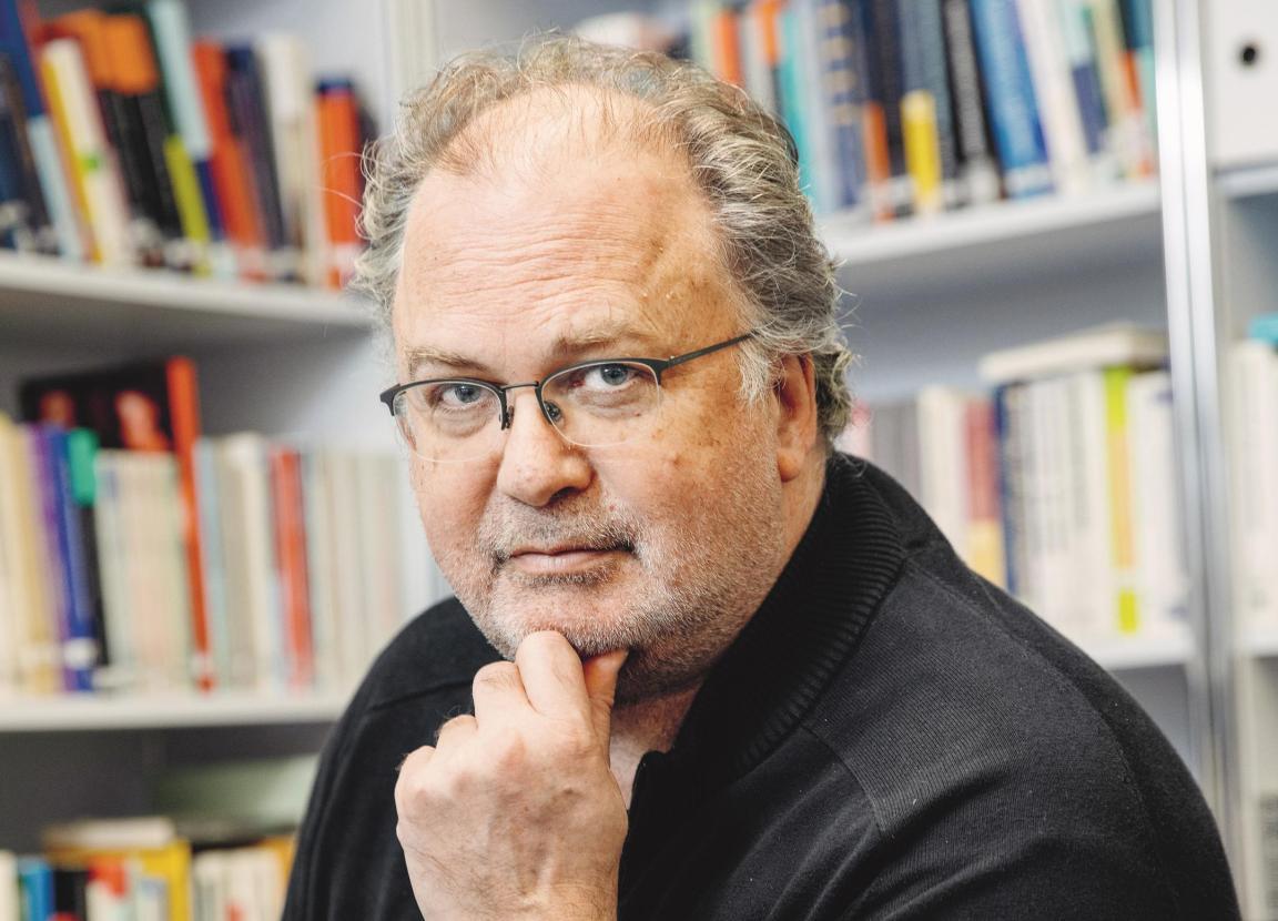 Herr mit Brille, ca. Mitte 50, schaut für das Portrait in die Kamera