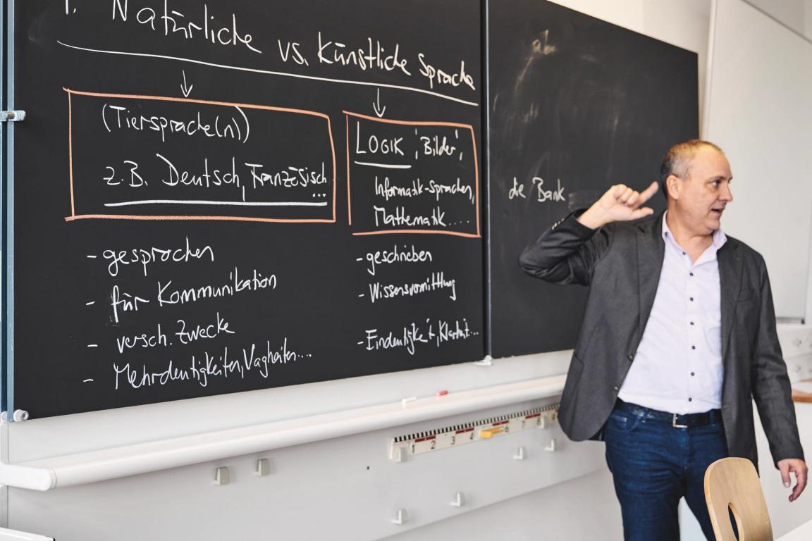 Unterrichtssituation, Lehrer steht vor Tafel