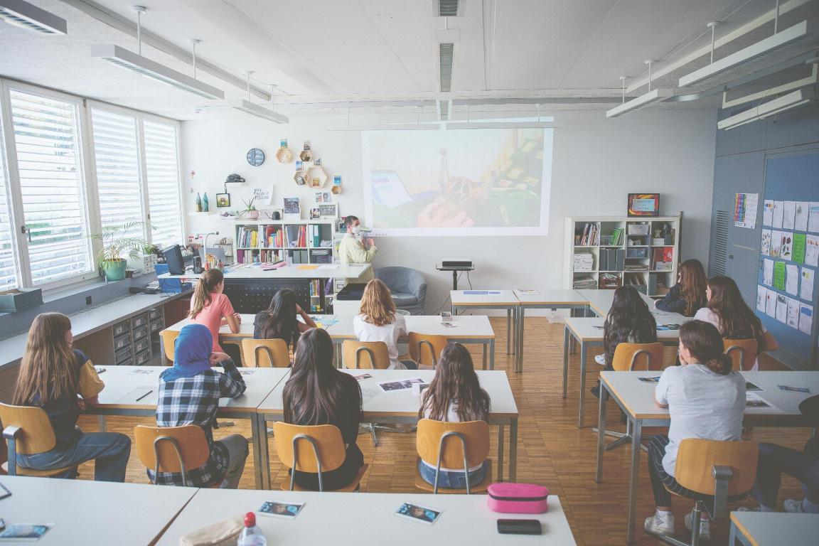 Schulklasse in einem Klassenzimmer, von hinten fotografiert
