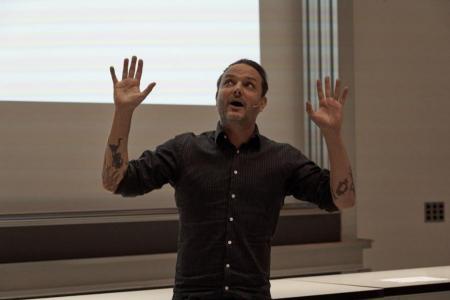 Der Komiker Dominic Deville gestikuliert mit seinen Armen während seinem Unterhaltungsprogramm.