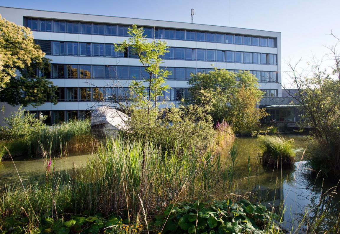  Aussenansicht der Forschungsanstalt Agroscope Reckenholz: Modernes, mehrstöckiges Gebäude mit Natur-Weiher..