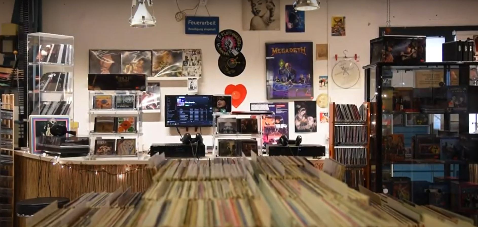 Schallplatten, CDs und Poster an der Wand im Brocki