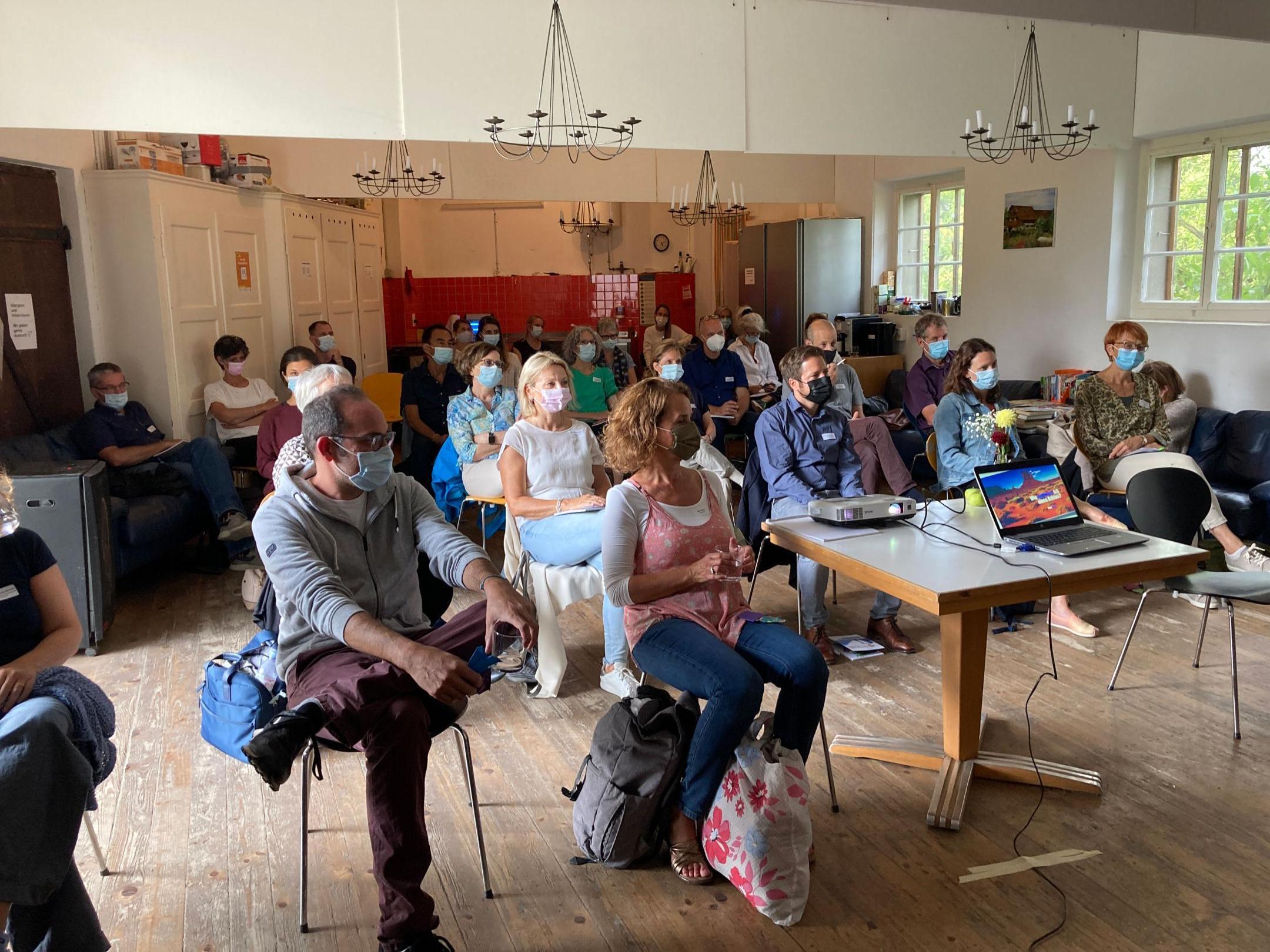 Publikum aus Frauen und Männern mit Masken