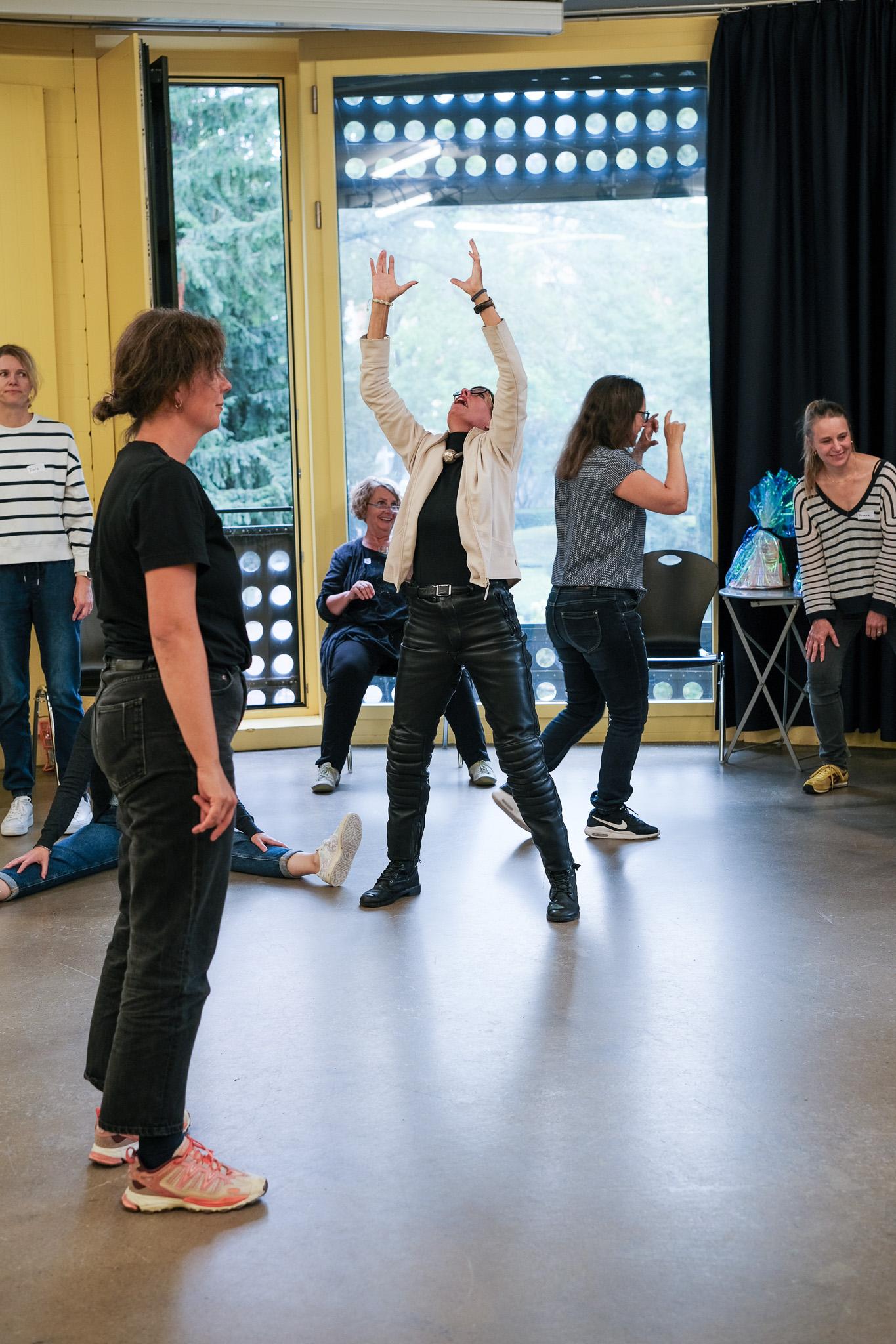 Eine Frau steht im Vordergrund, andere spielen dahinter